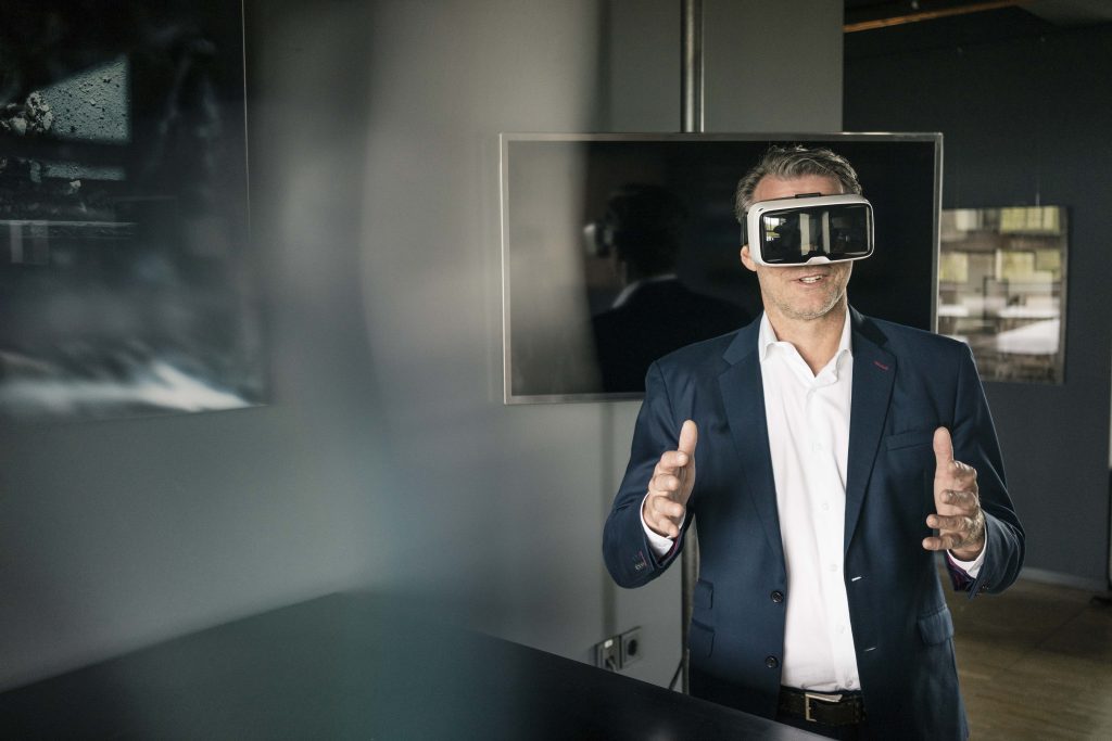 A businessman maknig a pitch with VR glasses on