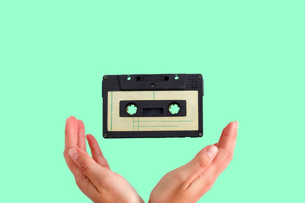 A cassette tape flies into a woman's hands