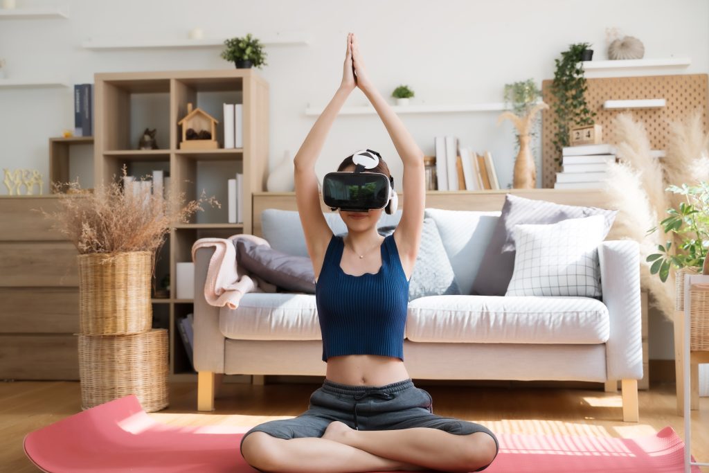 A young woman in VR glasses doing yoga